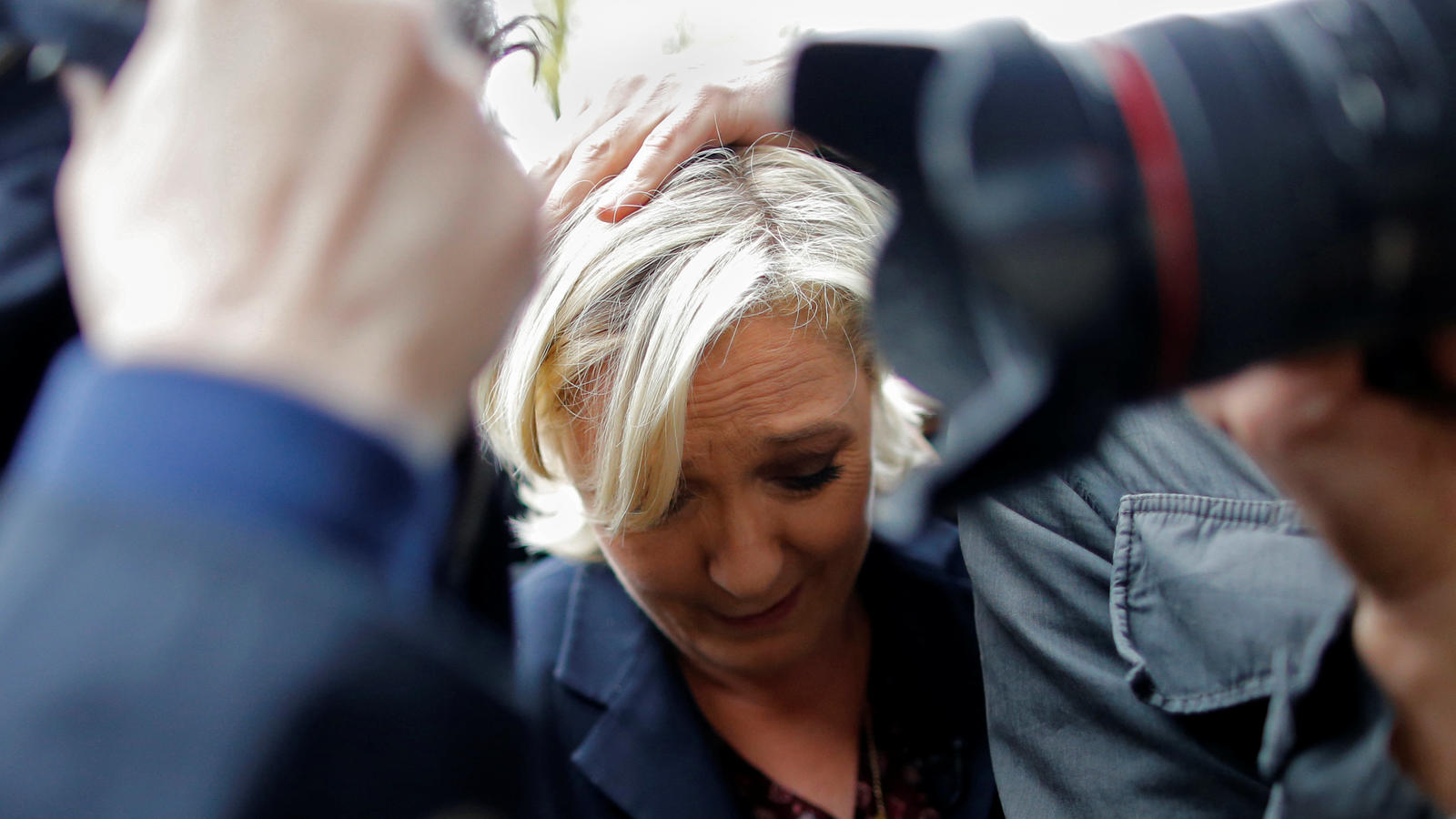Marine Le Pen, French National Front (FN) party candidate for 2017 presidential election, is protected by bodyguards as eggs are thrown by demonstrators during her arrival in Dol-de-Bretagne, France, May 4, 2017.   REUTERS/Stephane Mahe