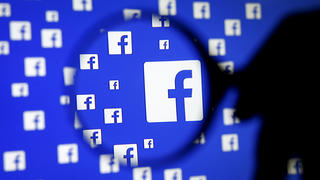 FILE PHOTO: A man poses with a magnifier in front of a Facebook logo on display December 16, 2015.   REUTERS/Dado Ruvic/Illustration/File Photo