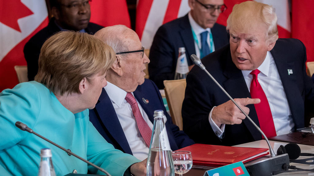 Bundeskanzlerin Angela Merkel (CDU) spricht am 27.05.2017 mit US-Präsident Donald Trump zu Beginn der Arbeitssitzung der G7 Staaten mit den Outreach Partnern in Taormina auf Sizilien (Italien), zwischen ihnen sitzt Tunesiens Präsident Beji Caid Esseb