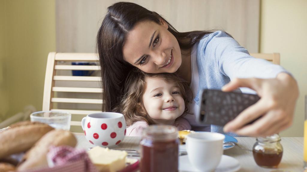 Portrait of mother and her little daughter taking a selfie at breakfast table model released Symbolfoto property released PUBLICATIONxINxGERxSUIxAUTxHUNxONLY HAPF000125Portrait of Mother and her Little Daughter Taking a Selfie AT Breakfast Table Mode