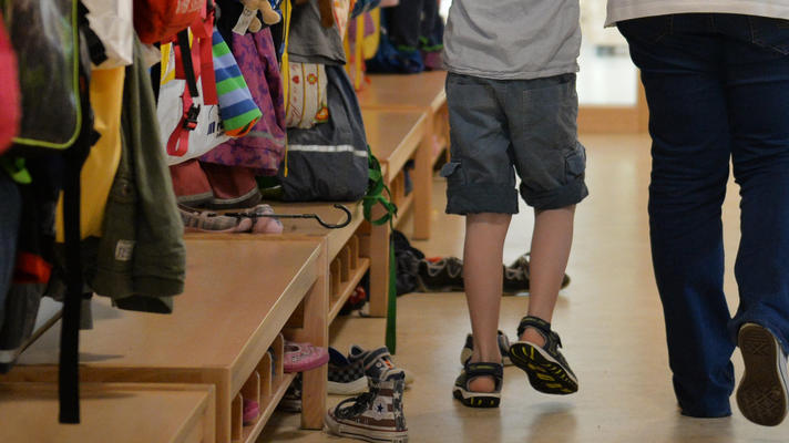 ARCHIV - Eine Erzieherin geht am 22.06.2016 im St. Michaels Kindergarten in Leinfelden-Echterdingen (Baden-Württemberg) mit zwei Kindern über den Flur der Einrichtung. In den Kitas in Mecklenburg-Vorpommern ist das Personal knapp. (zu dpa «Kritik an