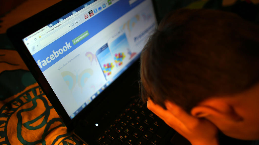 ARCHIV - ILLUSTRATION - Ein Junge reibt sich am 15.05.2013 in Leichlingen (Nordrhein-Westfalen) vor seinem Laptop beim Betrachten der Facebook- Seite die Augen. (zu dpa «Hass im Netz erreicht vor allem die Jungen» vom 30.05.2017) Foto: Oliver Berg/dp