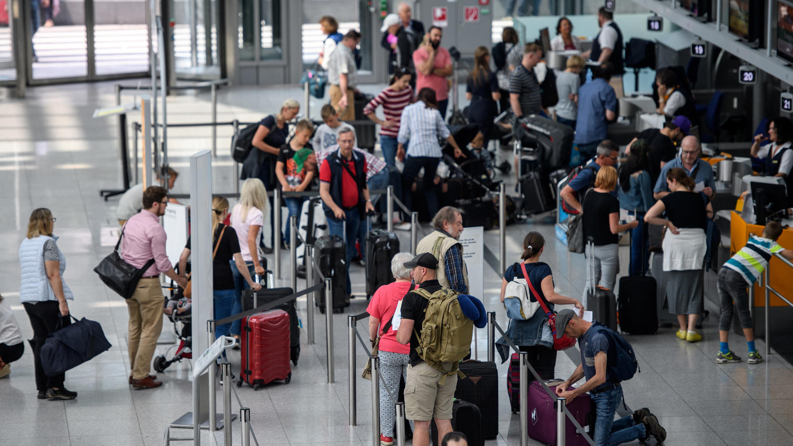 Reisende stehen an Check-In-Schaltern am Flughafen in München (Bayern). Zum Beginn der Pfingstferien in Bayern 02.06.2017 brechen zahlreiche Menschen in den Urlaub auf. Foto: Matthias Balk/dpa +++(c) dpa - Bildfunk+++