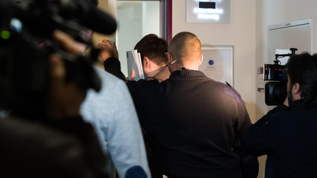 Einer der zwei Angeklagten (M) wird von einem Justizbeamten, am 26.04.2017 in Lübeck (Schleswig-Holstein), zum Beginn des Prozesses in den Gerichtssaal geführt. Den Angeklagten wird vorgeworfen, eine Zweijährige vergewaltigt zu haben. Sie mü