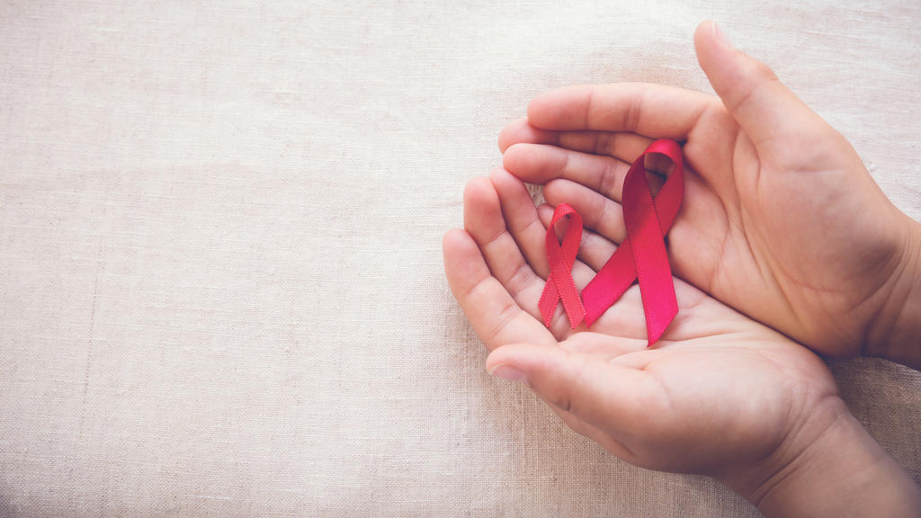 hands holding Red Ribbons on toning background, HIV/AIDS, Anosmia, Heart disease,Epidermolysis bullosa and Vasculitis awareness