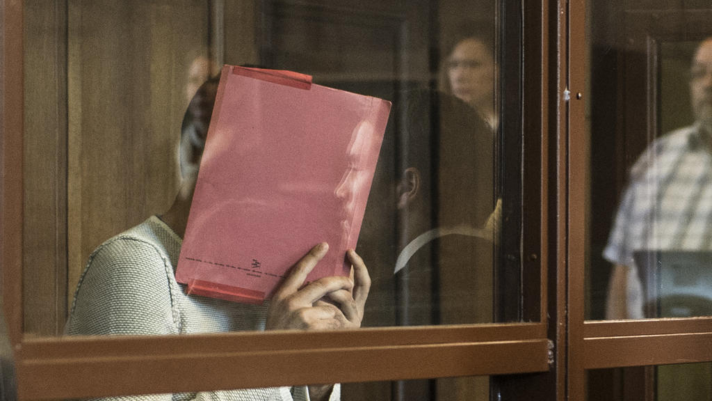 ARCHIV - Der Angeklagte Swetoslaw S. steht am 26.06.2017 in Berlin mit einer Mappe vor dem Gesicht hinter einer Glasscheibe in einem Gerichtssaal und muss sich wegen gefährlicher Körperverletzung verantworten. Am 29. Juni soll der Prozess gegen 28-Jä