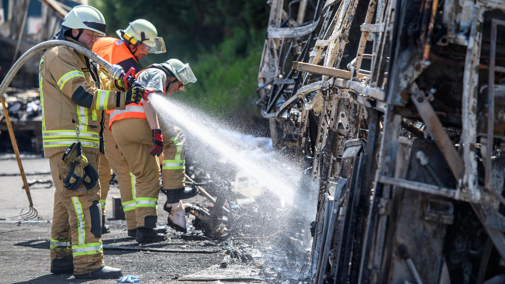 Das Buswrack wird am 03.07.2017 an der Unglücksstelle des verunfallten Reisebusses auf der Autobahn 9 bei Münchberg (Bayern) von Feuerwehrleuten gelöscht. Bei dem schweren Busunfall auf der Autobahn 9 in Oberfranken sind nach Erkenntnissen der Polize