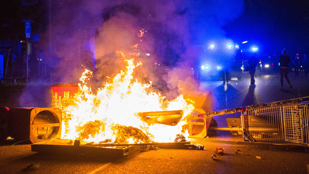 Polizisten stehen am 09.07.2017 in Hamburg im Schanzenviertel hinter einer brennenden Barrikade. Am 07. und 08. Juli kamen in der Hansestadt die Regierungschefs der führenden Industrienationen zum G20-Gipfel zusammen. In der Nacht zum 08.07 eskaliert