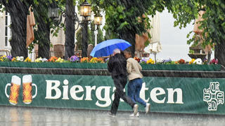 Ein Paar rennt am 01.06.2015 in Dresden (Sachsen) im Stadtzentrum bei einem Gewitterregen an einem Biergarten vorbei. Foto: Matthias Hiekel +++(c) ZB-FUNKREGIO OST - Honorarfrei nur für Bezieher des ZB-Regiodienstes+++ | Verwendung weltweit
