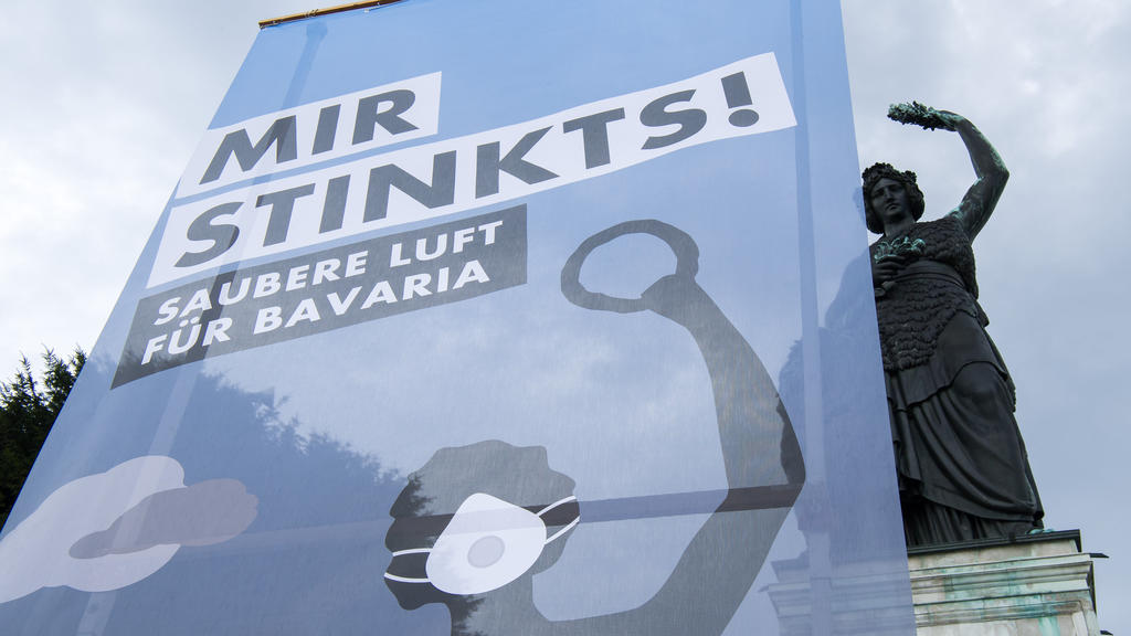 Aktivisten von "BUND Naturschutz in Bayern e.V." demonstrieren am 02.08.2017 mit einem großem Plakat mit der Aufschrift "Mir stinkts! Saubere Luft für Bavaria" unterhalb der Bavaria-Statue an der Theresienwiese in München (Bayern). Die Aktion fand ze