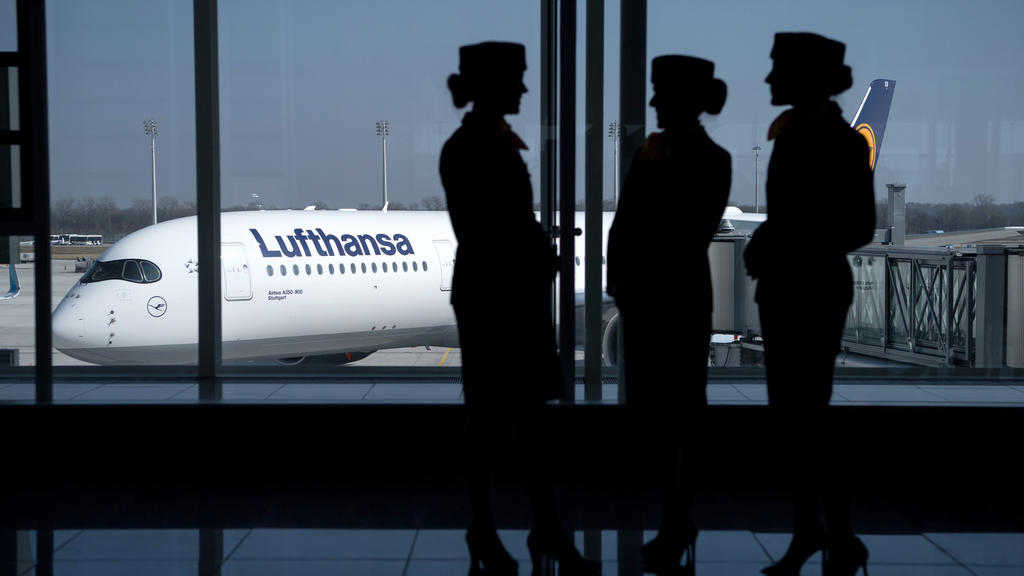 ARCHIV - Flugbegleiterinnen der Deutschen Lufthansa AG stehen am 16.03.2017 am Flughafen in München (Bayern) während der Bilanz Pressekonferenz der Deutschen Lufthansa AG vor einem Fenster am Terminal. (zu dpa «Hauptversammlung der Lufthansa ohne gro