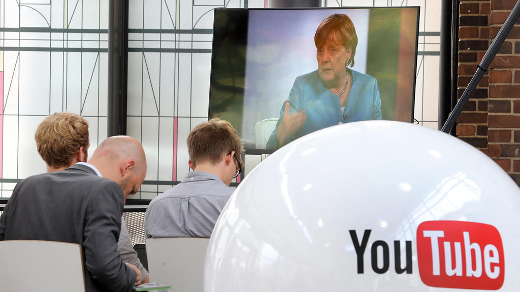 dpatopbilder - Zuschauer verfolgen in einem Nebenraum wie Bundeskanzlerin Angela Merkel (CDU), am 16.08.2017 in Berlin von YouTubern und der Online-Community in einem Livestream interviewt wird. Foto: Wolfgang Kumm/dpa +++(c) dpa - Bildfunk+++