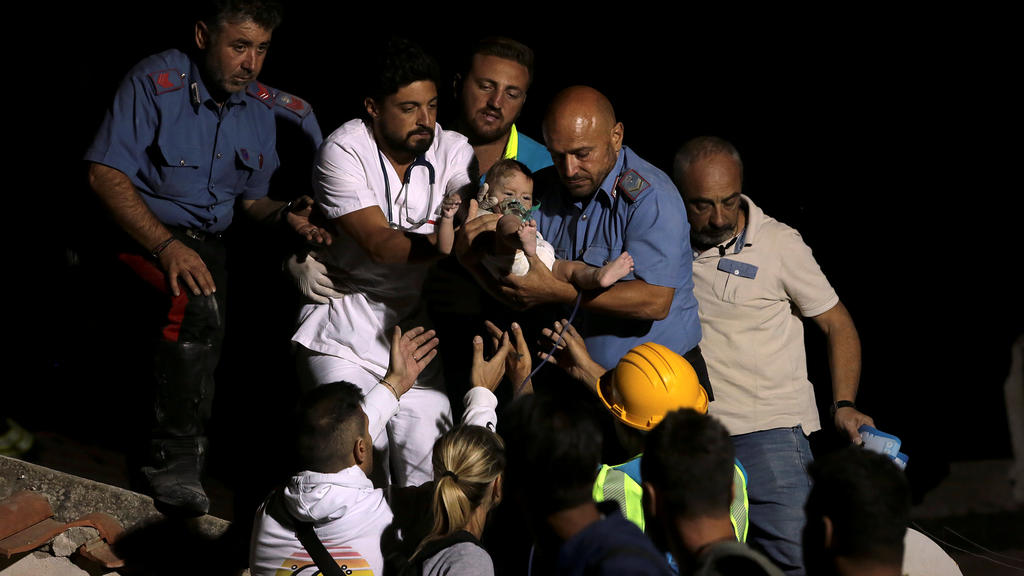 Italian Carabinieri police officer and a doctor carry a child after an earthquake hit the island of Ischia, off the coast of Naples, Italy August 22, 2017. REUTERS/Antonio Dilaurenzo NO RESALES. NO ARCHIVE