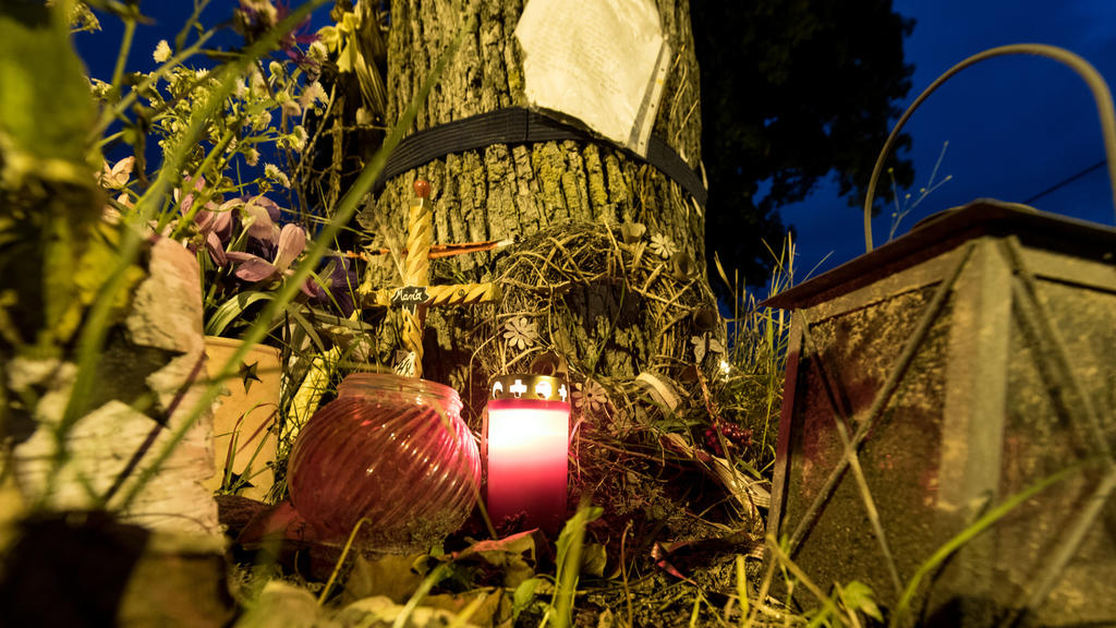 Ein Grablicht steht am Abend des 04.09.2017 in Freiburg (Baden-Württemberg) in der Nähe des Tatorts am Fluß Dreisam an einem Baum neben einem Kreuz mit der Aufschrift "Maria". Am 05.09.2017 beginnt im Freiburger Landgericht der Prozess gegen Hussein 