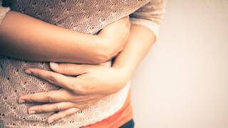 Young beautiful woman having painful stomachache.Chronic gastritis. Abdomen bloating concept.