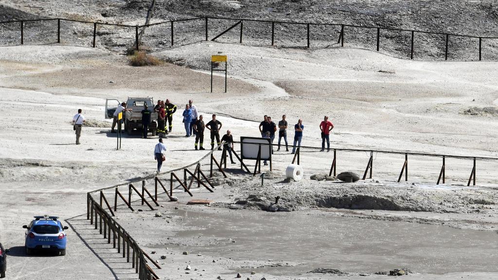 Feuerwehrmänner und Polizisten stehen am 12.09.2017 auf einem Vulkanfeld in Pozzuoli in der Nähe von Neapel (Italien). Ein elfjähriger Junge und dessen Eltern sind in einem Krater des Vulkanfelds ums Leben gekommen. (zu dpa «Eltern und Kind sterben i