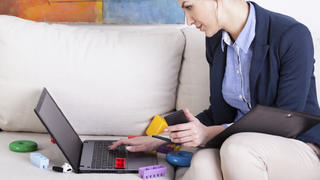 Young mother using laptop to work at home, horizontal