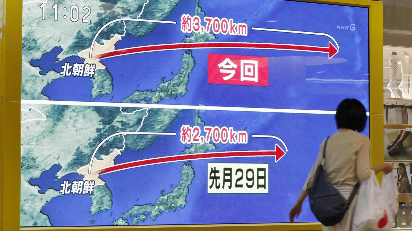 Eine Frau geht am 15.09.2017 in Sapporo (Japan) an einem Monitor vorbei, auf dem der erneute nordkoreanische Raktentest illustriert wird. Zwölf Tage nach seinem weltweit verurteilten Atomtest hat Nordkorea erneut eine Rakete über Japan hinweg in den 