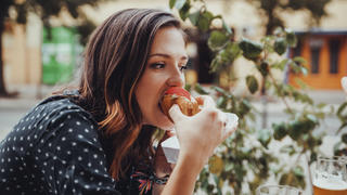 Young Woman Eating A Hotdog
