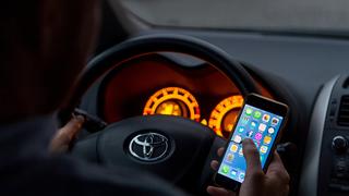 ARCHIV - ILLUSTRATION - Ein Mann sitzt am 03.04.2017 in Berlin in einem Auto am Steuer und hält ein Smartphone in der Hand (gestellte Szene). Foto: Monika Skolimowska/dpa (zu dpa "Fahrlehrer warnen vor Folgen bei Handy am Steuer" vom 28.04.2017) Foto: Monika Skolimowska/dpa +++(c) dpa - Bildfunk+++
