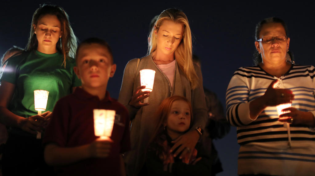 People pray during a candlelight vigil for victims of the Route 91 music festival mass shooting next to the Mandalay Bay Resort and Casino in Las Vegas, Nevada, U.S. October 3, 2017. REUTERS/Lucy Nicholson