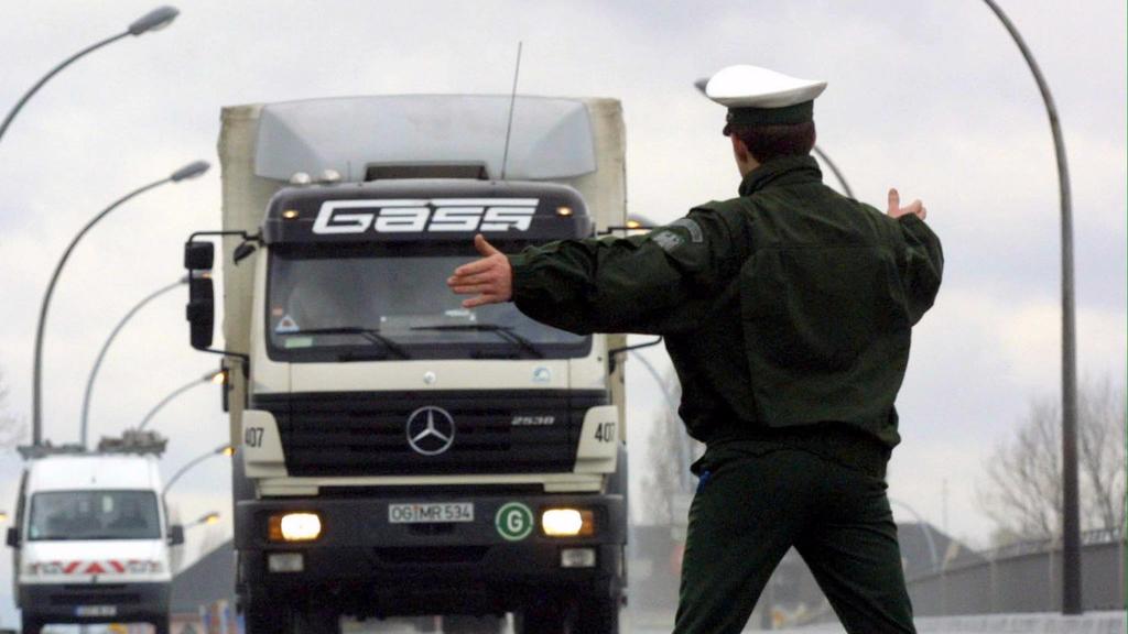 Ein deutscher Polizist winkt bei einer Kontrolle am 14.3.2001 an der deutsch-französischen Grenze bei Kehl einen Lastwagen heraus, der nach Deutschland einreisen will.