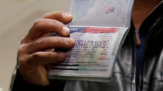 FILE PHOTO: A member of the Al Murisi family, Yemeni nationals who were denied entry into the U.S. because of the travel ban, shows the cancelled visa in their passport from their failed entry to reporters as they successfully arrive to be reunited with their family at Washington Dulles International Airport in Chantilly, Virginia, U.S., February 6, 2017.  REUTERS/Jonathan Ernst/Files