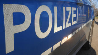 ARCHIV - ILLUSTRATION: Zwei Polizisten gehen am 25.01.2012 durch einen Park in Stuttgart. Im Vordergrund steht ein Polizeifahrzeug. (zu dpa: «Zeitung: Sichtbare Tattoos sollen Polizisten erlaubt werden» vom 09.10.2017) Foto: Franziska Kraufmann/dpa +++(c) dpa - Bildfunk+++
