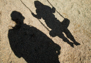 ARCHIV - Der Schatten von einem Mann und einem schaukelnden Kind fallen am 27.08.2014 auf Sand auf einem Spielplatz  in Braunschweig (Niedersachsen). Dank der aufsehenerregenden öffentlichen Fahndung mit Missbrauchsfotos eines vierjährigen Mädchens haben die Ermittler einen 24-Jährigen aus dem niedersächsischen Landkreis Wesermarsch festgenommen. (zu dpa «Fahndungserfolg in Missbrauchsfall: 24-jähriger Mann festgenommen» vom 10.10.2017) Foto: Julian Stratenschulte/dpa +++(c) dpa - Bildfunk+++