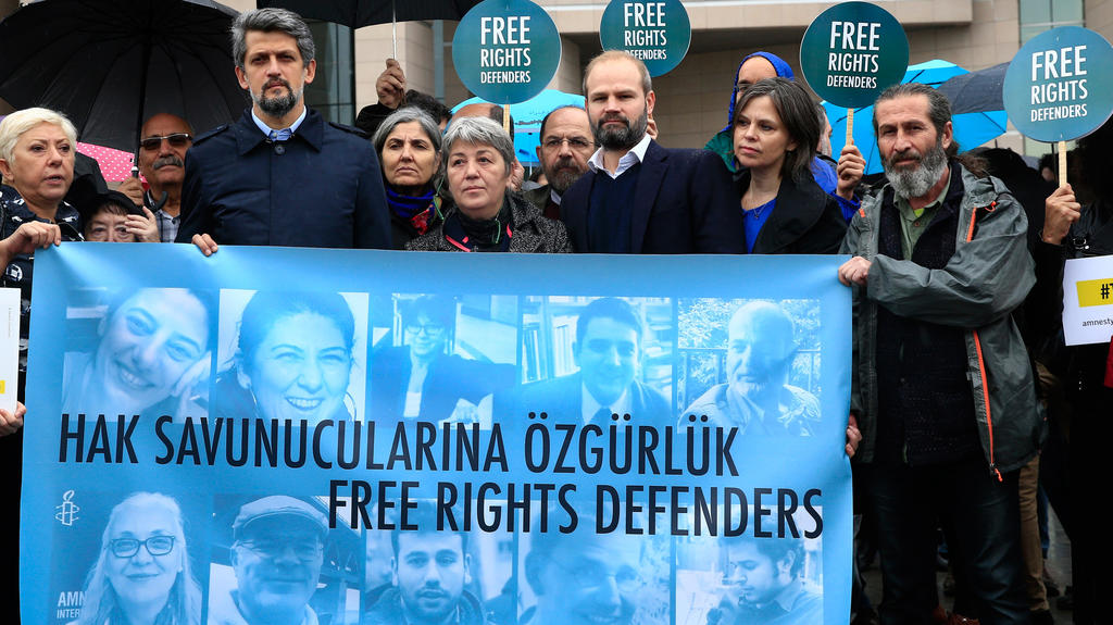 Menschenrechts-Aktivisten demonstrieren am 25.10.2017 vor einem Gericht in Istanbul (Türkei) mit einem Transparent mit Bildern der Angeklagten gegen den Prozess gegen elf Menschenrechtler, darunter auch der Deutsche Peter Steudtner (auf dem Banner de