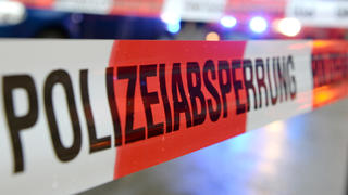 ARCHIV  - Ein Flatterband mit der Aufschrift «Polizeiabsperrung» ist am 05.11.2014 in Freiburg (Baden-Württemberg) an einem Einsatzort vor einem Feuerwehrfahrzeug mit Blaulicht zu sehen (Illustration zum Thema Polizeiabsperrung). Mehrere Menschen sind in München (Bayern) von einem Unbekannten mit einem Messer angegriffen und verletzt worden. Foto: Patrick Seeger/dpa +++(c) dpa - Bildfunk+++