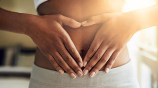 Cropped shot of a sporty young woman making a heart with her hands on her stomach