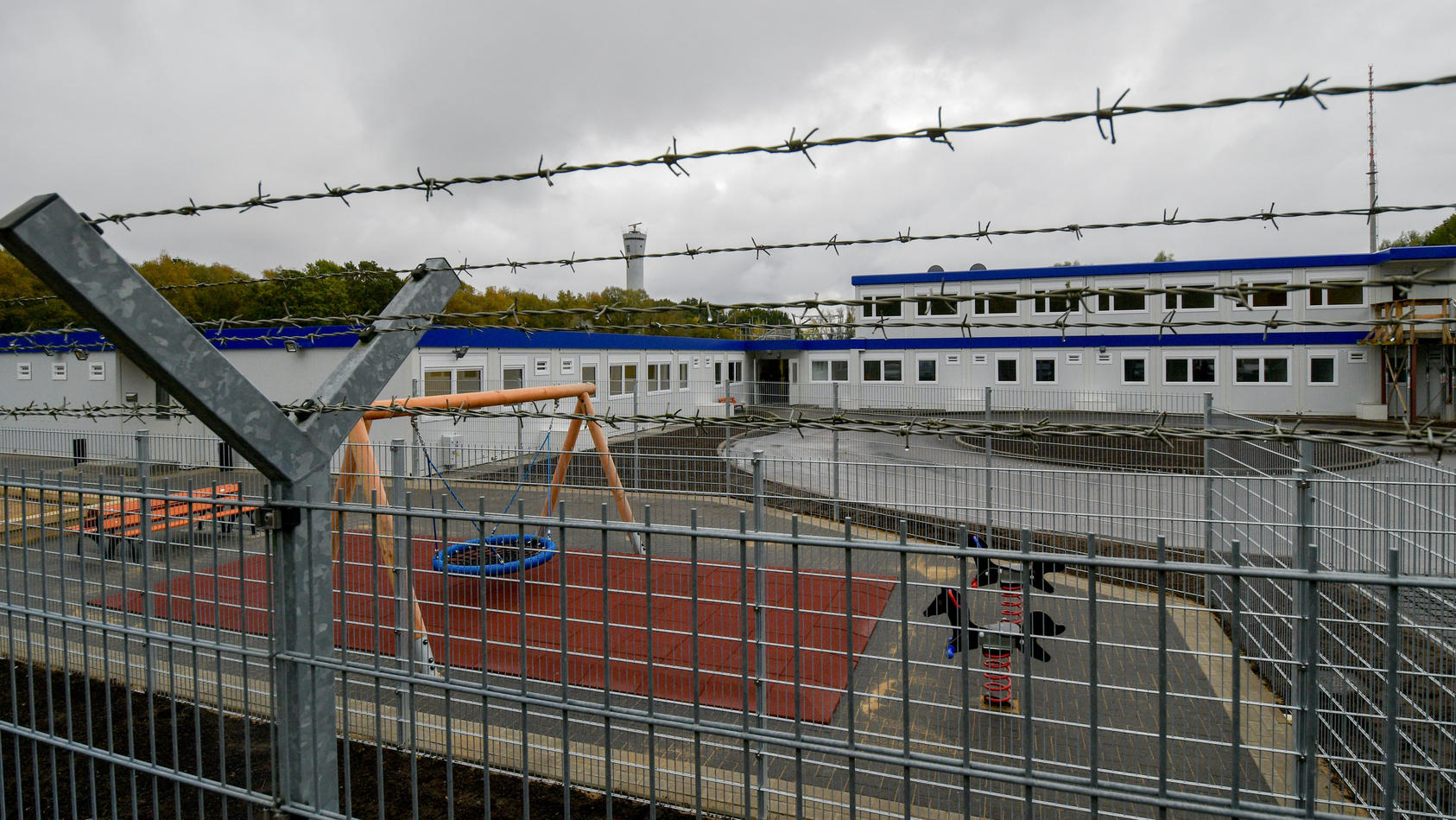 ARCHIV - Stacheldraht umgibt am 21.10.2016 in Hamburg die Container des neuen Ausreisegewahrsams am Flughafen. Aus der Abschiebe-Unterkunft am Airport sind zwei Menschen geflohen und aufs Rollfeld gelaufen. Die Abschiebe-Einrichtung wurde am Hamburge