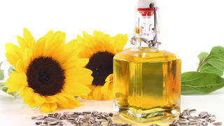 eine Flasche Sonnenblumenöl mit Sonnenblumen