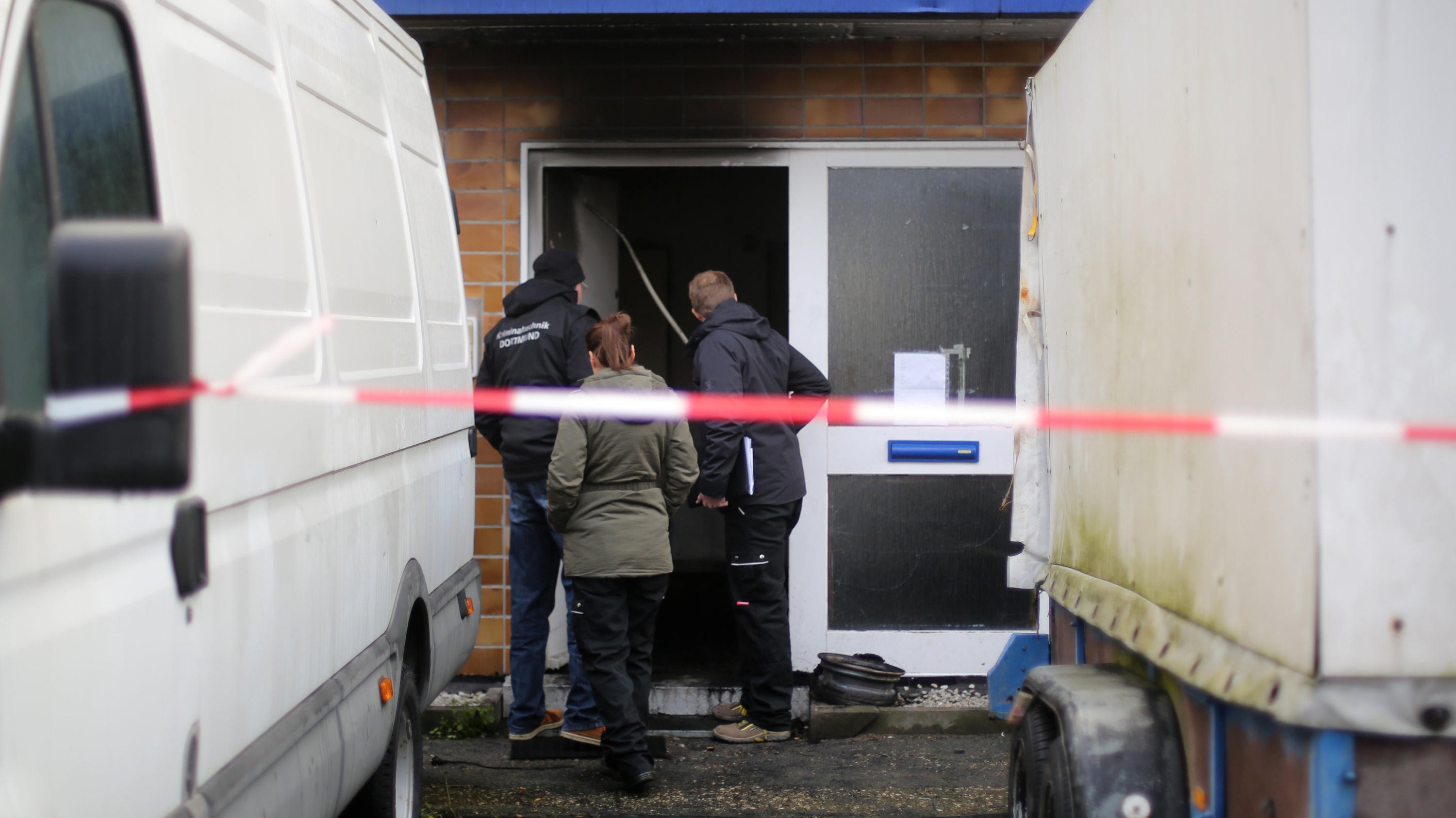 Kriminaltechniker begutachten am 01.12.2017 in Bergkamen (Nordrhein-Westfalen) den Eingang zu einem Haus, in dem es in der Nacht gebrannt hat. Bei dem Brand sind sieben Menschen lebensgefährlich verletzt worden. Foto: Ina Fassbender/dpa +++(c) dpa - 