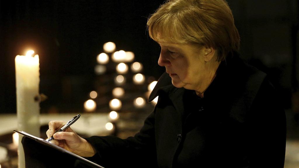 Bilder des Tages December 20, 2016 - Berlin, GERMANY - German Chancellor Angela Merkel signs the condolence book at the Memorial Church in Berlin, Germany, Tuesday Dec. 20, 2016, one day after a truck ran into a crowded Christmas market in Berlin and