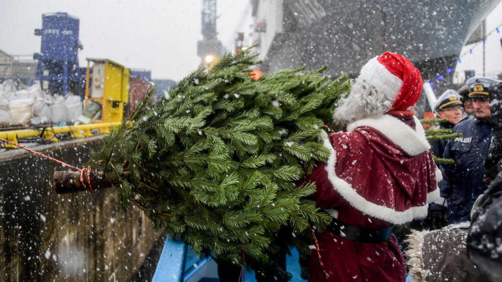 Ein Weihnachtsmann überreicht am 08.12.2017 in Hamburg der Besatzung des Einsatzgruppenversorgers "Berlin" der Bundeswehr einen Weihnachtsbaum. Traditionell werden in jedem Jahr Weihnachtsbäume für die Schiffe im Hamburger Hafen verschenkt. Foto: Axe