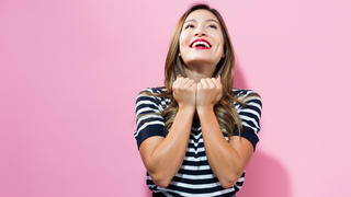 Successful young woman on a pink background
