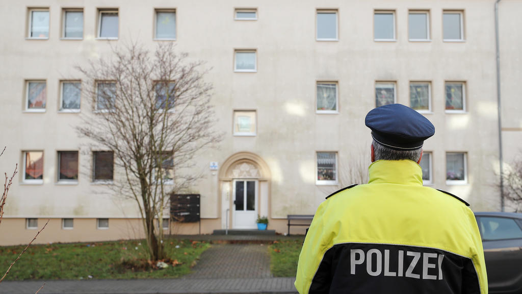 Ein Polizist steht am 03.01.2018 vor einem Haus in Benndorf (Sachsen-Anhalt). In einer Wohnung in diesem Haus hat die Polizei zwei tote Säuglinge gefunden. Die 46 Jahre alte Mutter wurde vorläufig festgenommen. Woran die beiden Kinder gestorben sind,