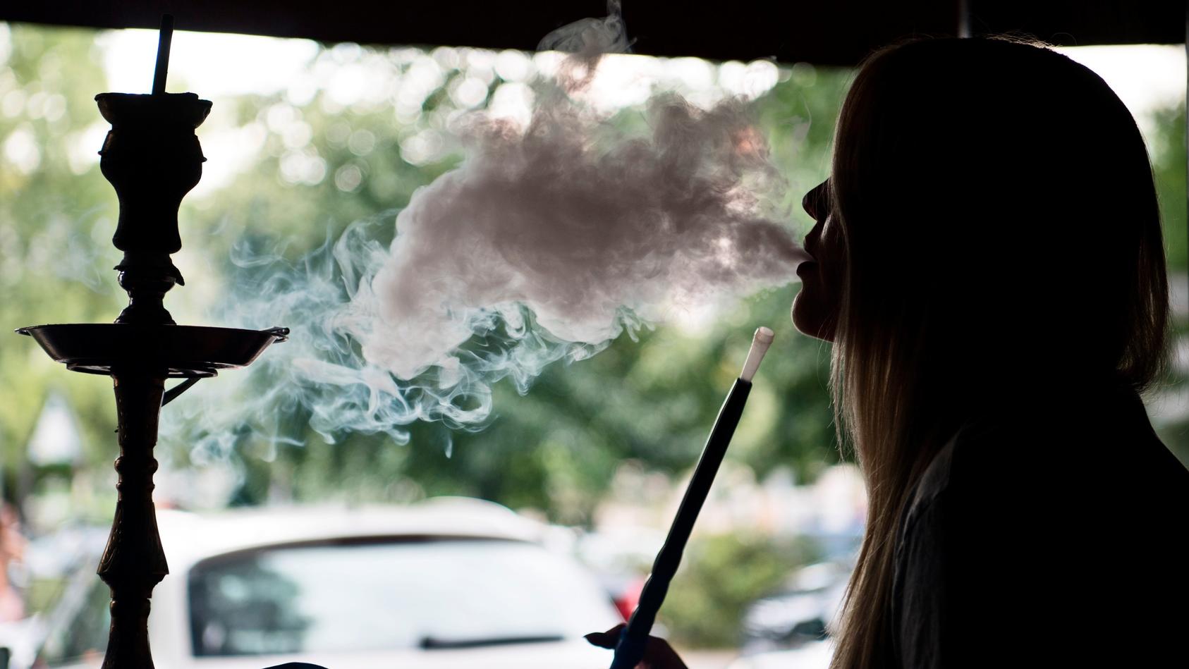 Eine junge Frau raucht am 21.07.2016 in einer Shisha-Bar in Berlin Tabak der Sorte «Traube-Minze» in einer Wasserpfeife. Shisha-Rauchen liegt im Trend: Die arabische Wasserpfeife ist besonders bei jungen Leuten beliebt.