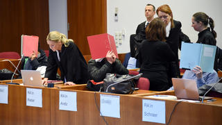 Angeklagte und Anwälte warten am 10.01.2018 im Landgericht in Bonn (Nordrhein-Westfalen) auf den Beginn ihrer Verhandlung. Die fünf Angeklagten sollen europaweit Autounfälle fingiert und über Versicherungen abgerechnet haben. (ACHTUNG: Die Namensschilder der Angeklagten wurden aus persönlichkeitsrechtlichen Gründen unkenntlich gemacht.) Foto: Henning Kaiser/dpa +++(c) dpa - Bildfunk+++