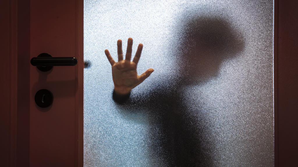Kind hinter einer Glastür