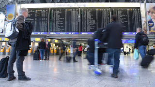 ARCHIV - Passagiere gehen am 06.11.2015 auf dem Flughafen in Frankfurt am Main (Hessen) an der Anzeigetafel vorbei. (zu dpa: "Ryanair & Co. bescheren Fraport Passagierrekord in Frankfurt" vom 15.01.2018) Foto: Boris Roessler/dpa +++(c) dpa - Bildfunk+++