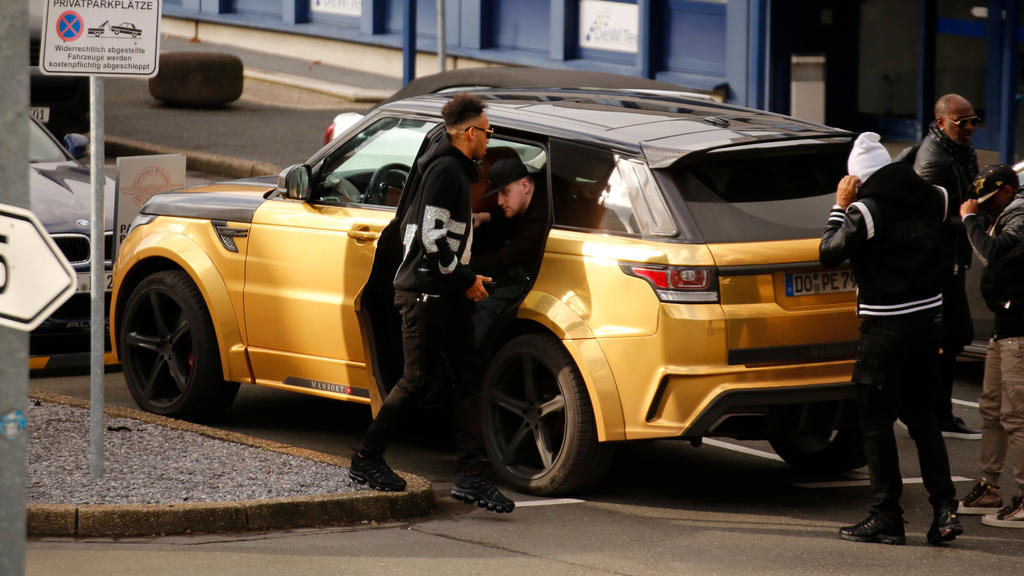 30.01.2018, Nordrhein-Westfalen, Dortmund: Pierre-Emerick Aubameyang (l) von Borussia Dortmund kommt mit einem goldfarbenen Land Rover zum Flughafen. (zu dpa «Aubameyang-Wechsel zu Arsenal erwartet - BVB-Training am Nachmittag» vom 30.01.2018) Foto: