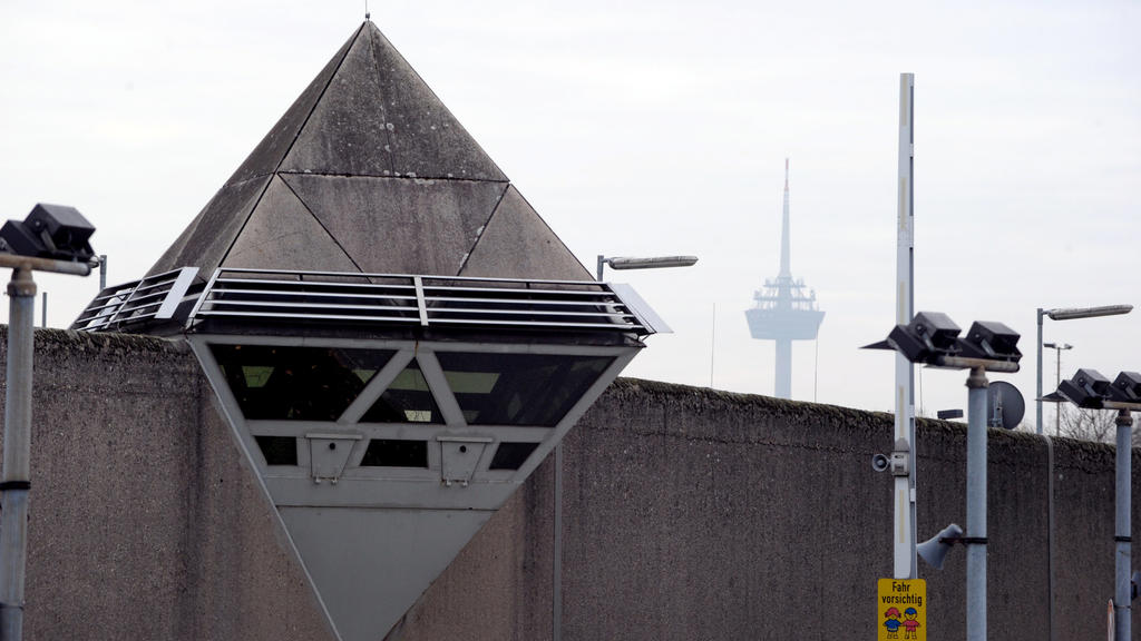 ARCHIV - 18.11.2011, Nordrhein-Westfalen, Köln: Wachtürme und Sicherheitskameras sind auf der Mauer der Justizvollzugsanstalt Ossendorf zu sehen. (zu dpa: "Gefangener bei Feuer in der JVA Köln schwer verletzt") Foto: Federico Gambarini/dpa +++ dpa-