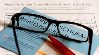 ARCHIV - ILLUSTRATION - Eine Brille und ein Kugelschreiber liegen am 26.04.2014 in Berlin auf einem Informationsblatt und einem Antrag für eine Schufa-Auskunft. (zu dpa «Kritik an Schufa-Eintrag nach Ende des Insolvenzverfahrens» vom 04.02.2018) Foto: Jens Kalaene/dpa-Zentralbild/dpa +++ dpa-Bildfunk +++