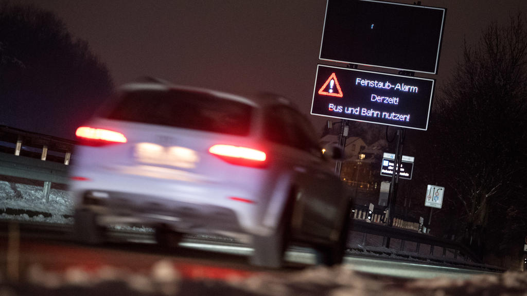 19.02.2018, Baden-Württemberg, Stuttgart: Ein Auto fährt an einem Schild vorbei, das auf den Feinstaub-Alarm hinweist. Am 22. Februar wird das Urteil des Bundesverwaltungsgerichts erwartet, ob Städte mit hoher Stickoxid-Belastung Diesel-Fahrverbote v
