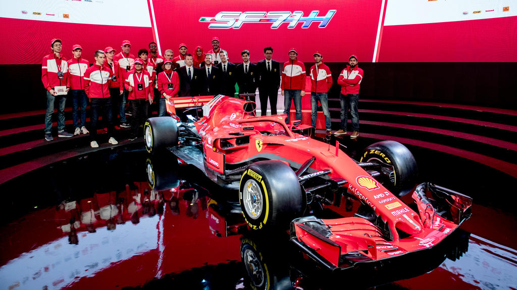 HANDOUT - 22.02.2018, Italien, Maranello: Vorstellung des neuen Ferrari SF71H mit Sebastian Vettel (M, 2.v.l) und dem Ferrari-Team. Ferrari lüftete als letztes der drei Top-Teams der Formel 1 das Geheimnis um den neuen Rennwagen. (zu dpa Formel 1 le