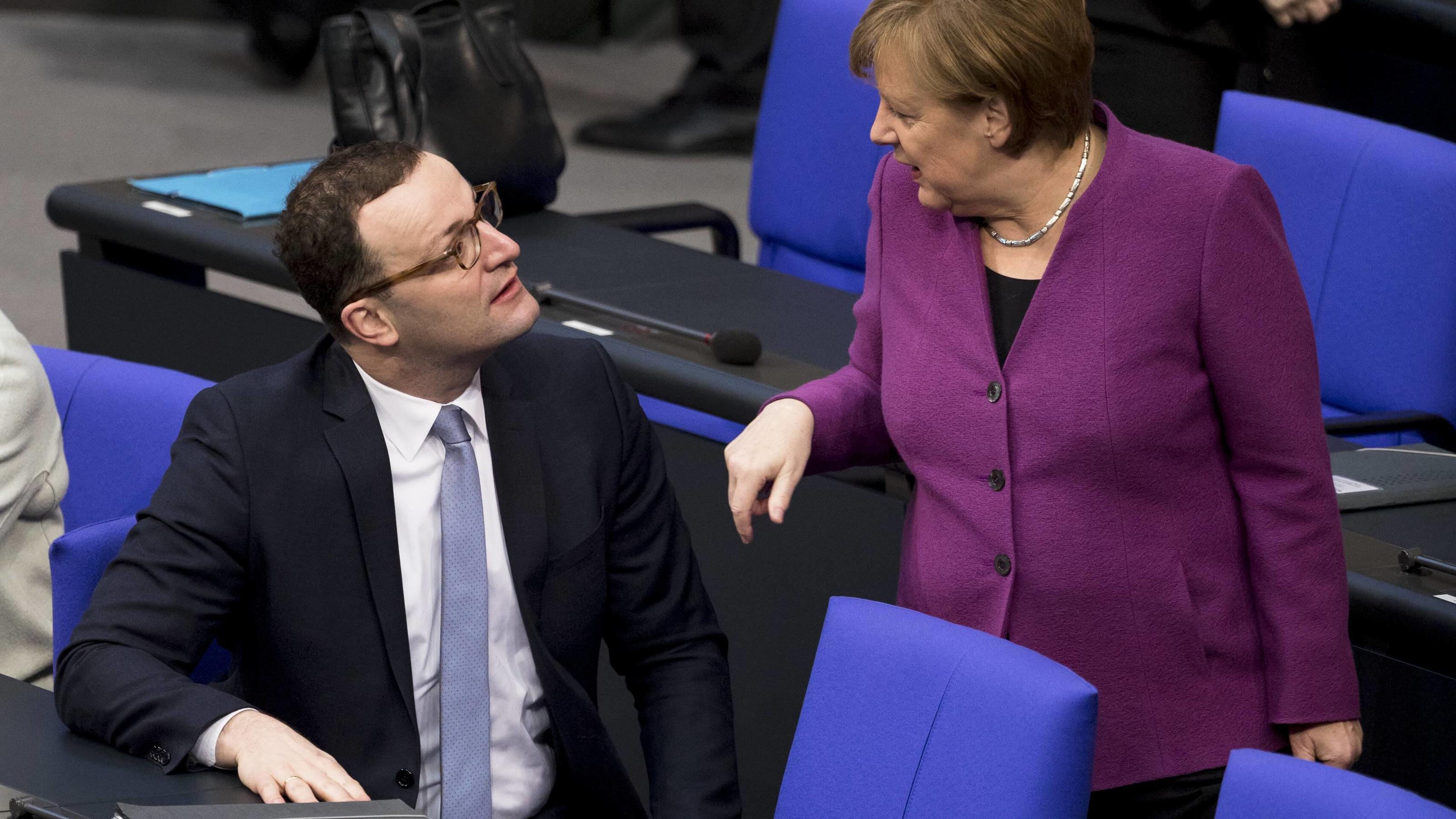 February 22, 2018 - Berlin, Germany - German Chancellor Angela Merkel (R) speaks with Jens Spahn (L) as she arrives to the 14. plenary session at Bundestag (lower house of parliament) in Berlin, Germany on February 22, 2018. Berlin Germany PUBLICATIO