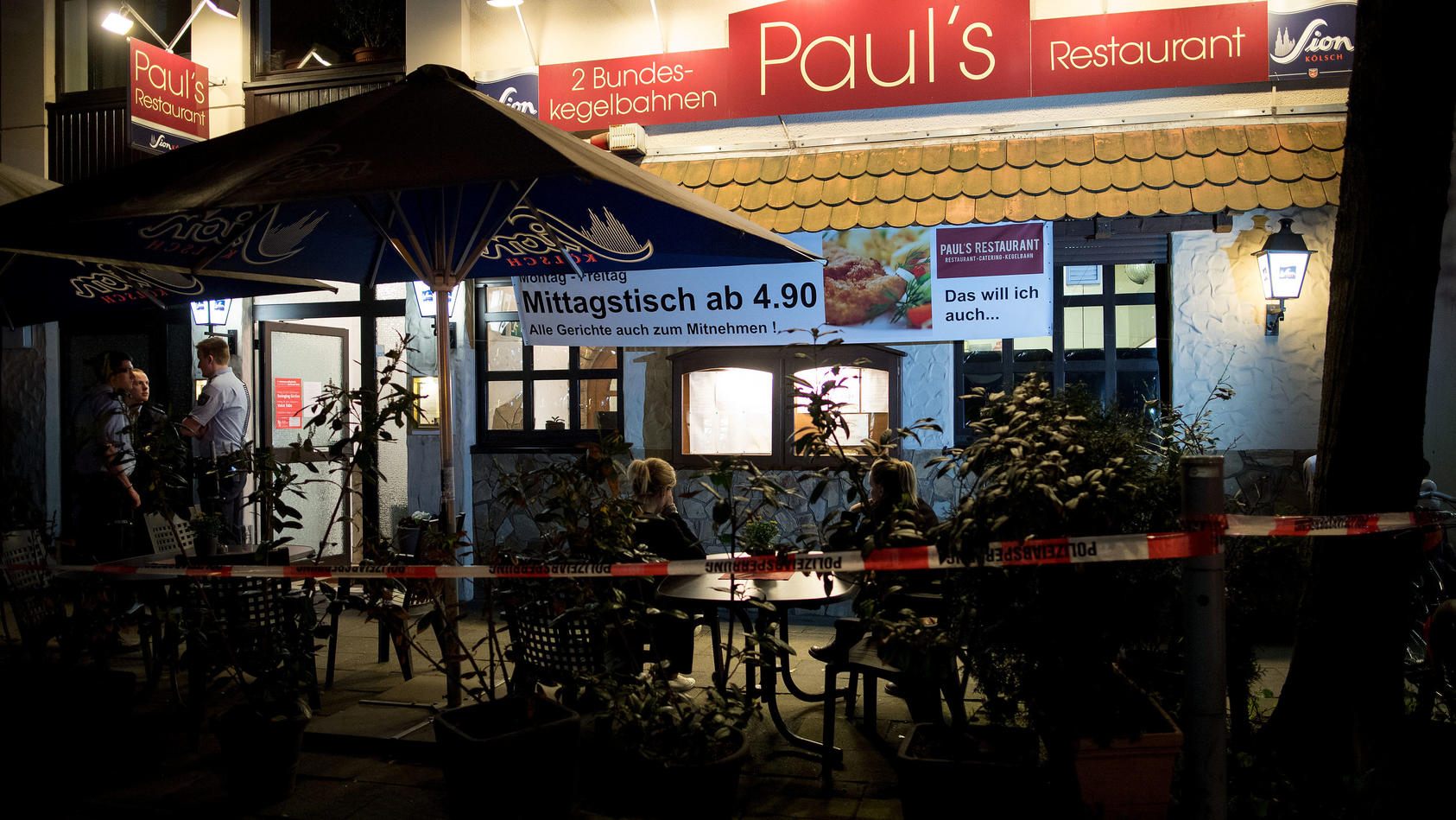 13.04.2018, Nordrhein-Westfalen, Köln: Polizisten stehen vor einem Restaurant. Im Keller des Restaurants hat die Polizei zwei Leichen gefunden. Wie der Mann und die Frau starben und in welcher Beziehung sie zueinander standen, dazu machte die Polizei